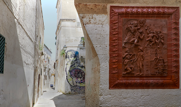 Pumi e pupe Via Madonna del Lume pannello sul prete brigante Ciro Annicchiarico e, alle spalle, murales