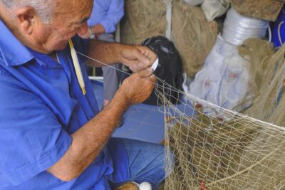 Pescatore che ripara le reti (ph. emilio dati © mondointasca.it)