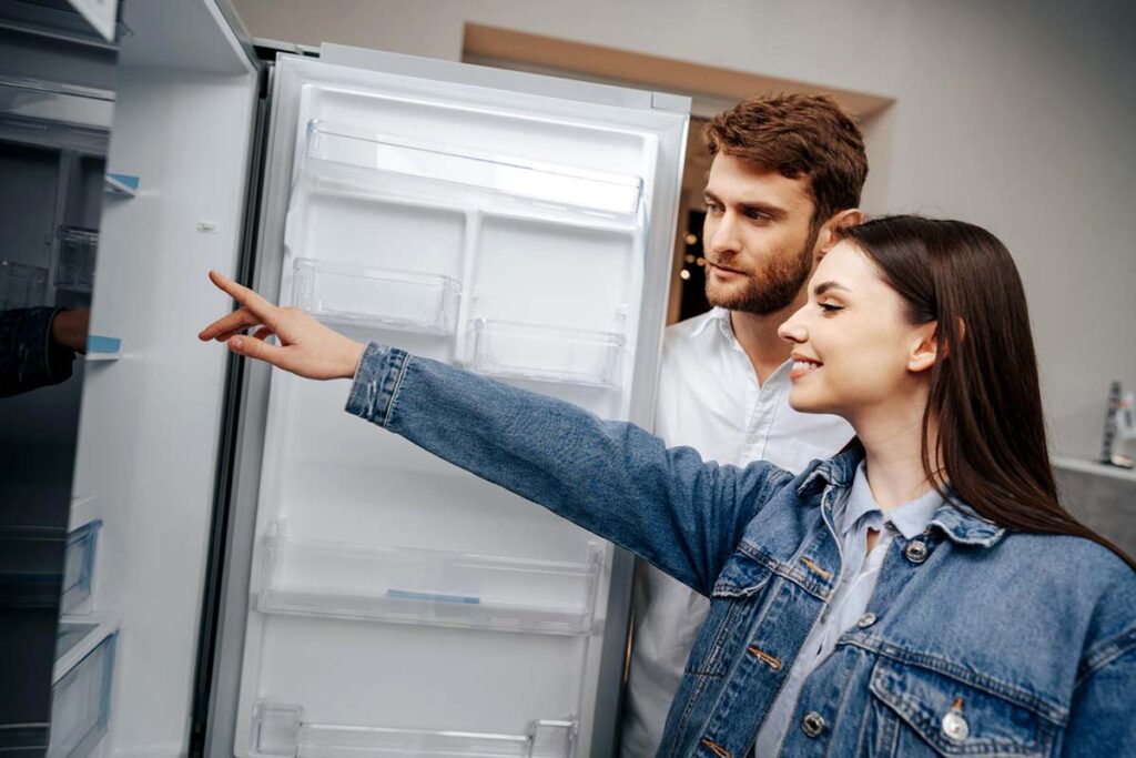 elettrodomestici Giovane coppia mentre sceglie un frigorifero