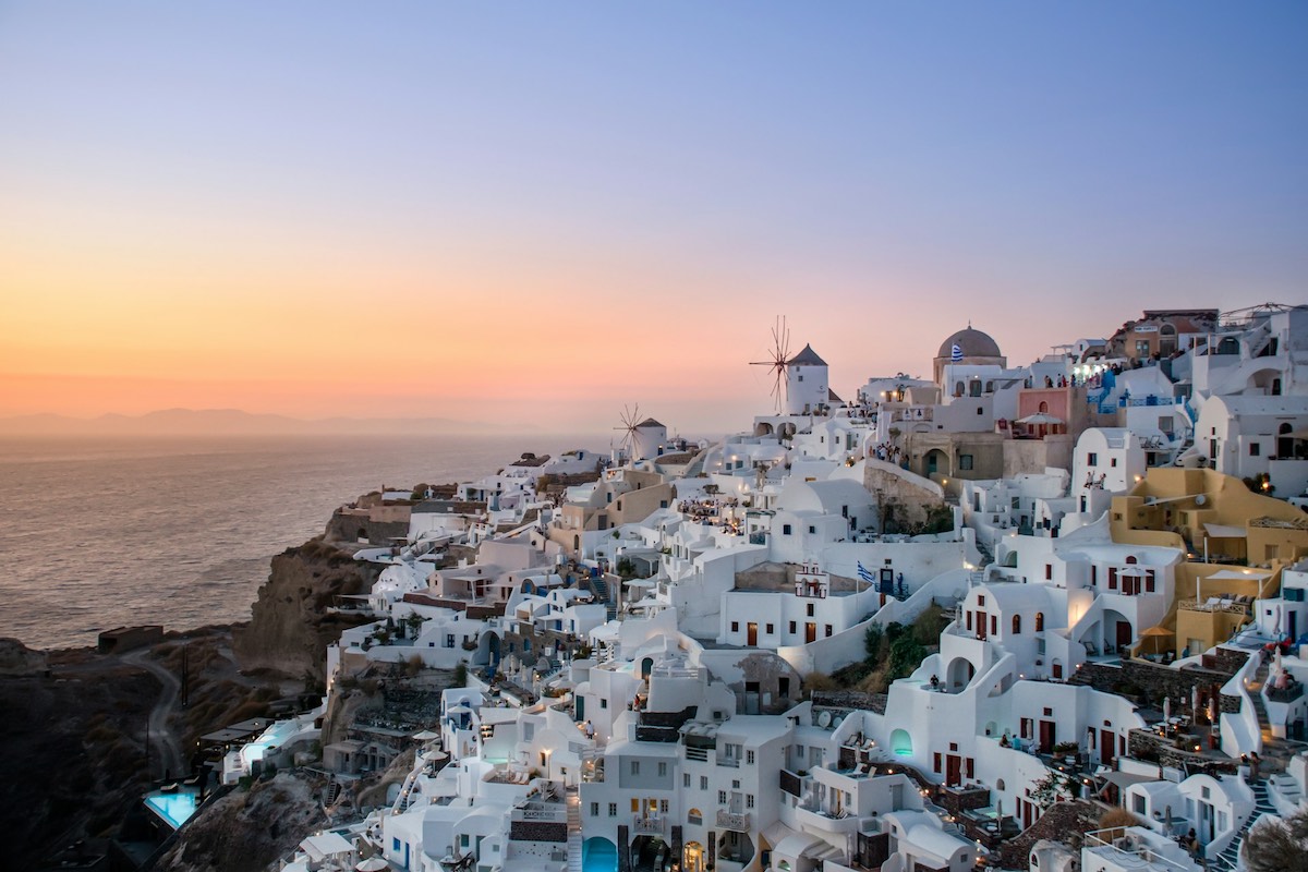 Tramonto a Santorini su un villaggio affacciato sulla scogliera
