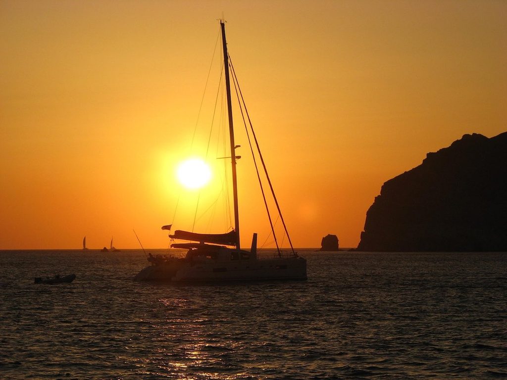 Tramonti a Santorini: i posti più belli dove vedere il sole scendere sul mare 6 Catamarano al tramonto sul mare di Santorini